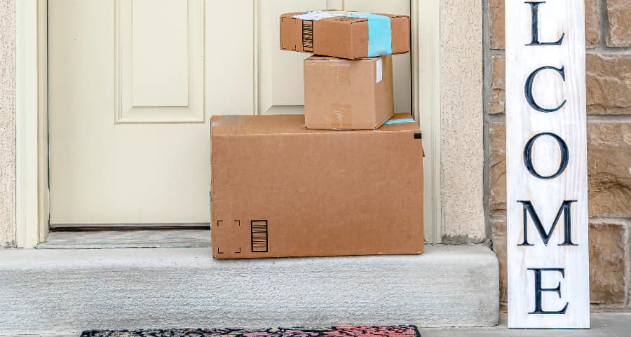 Packages on the doorstep of a home with a welcome sign in Las Cruces